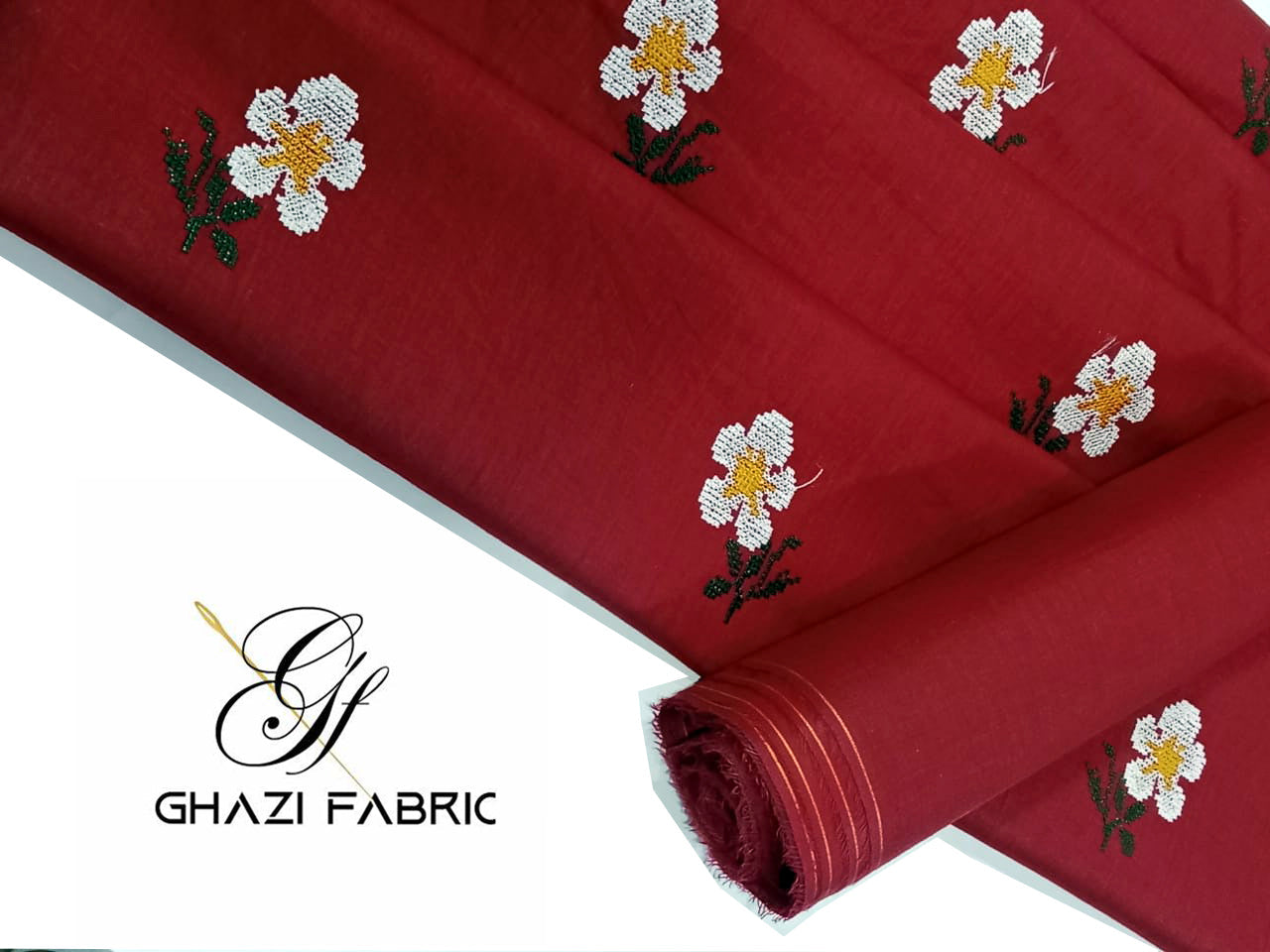 Red fabric with floral embroidery on a white background, featuring the Ghazi Fabrics logo.