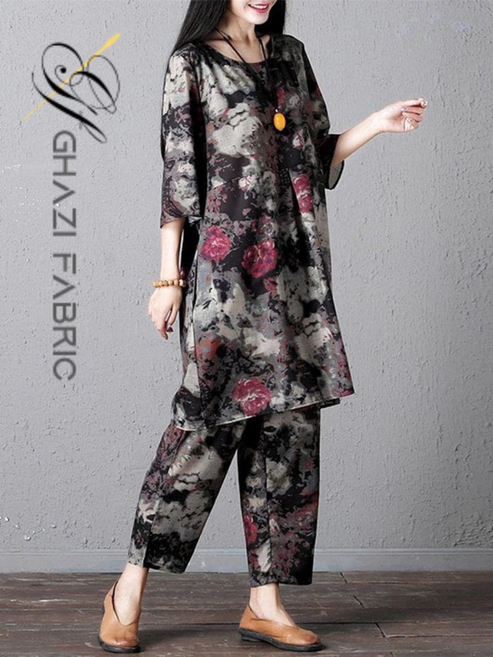 Woman wearing a floral outfit with 'Ghazi Fabric' logo on a gray background
