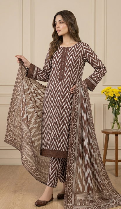 Woman wearing a patterned outfit with a matching dupatta in an indoor setting.
