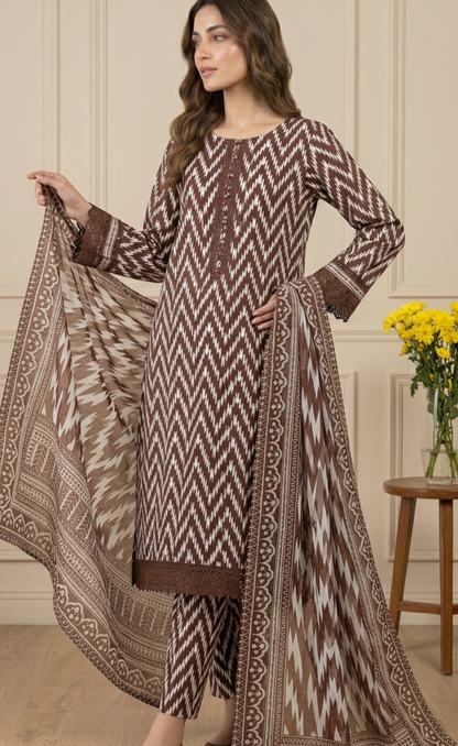 Woman wearing a patterned outfit with a matching dupatta in an indoor setting.