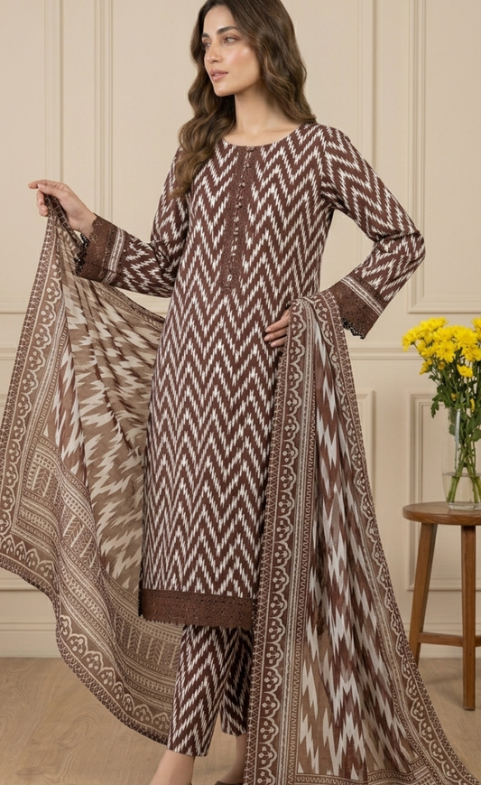 Woman wearing a patterned outfit with a matching dupatta in an indoor setting.