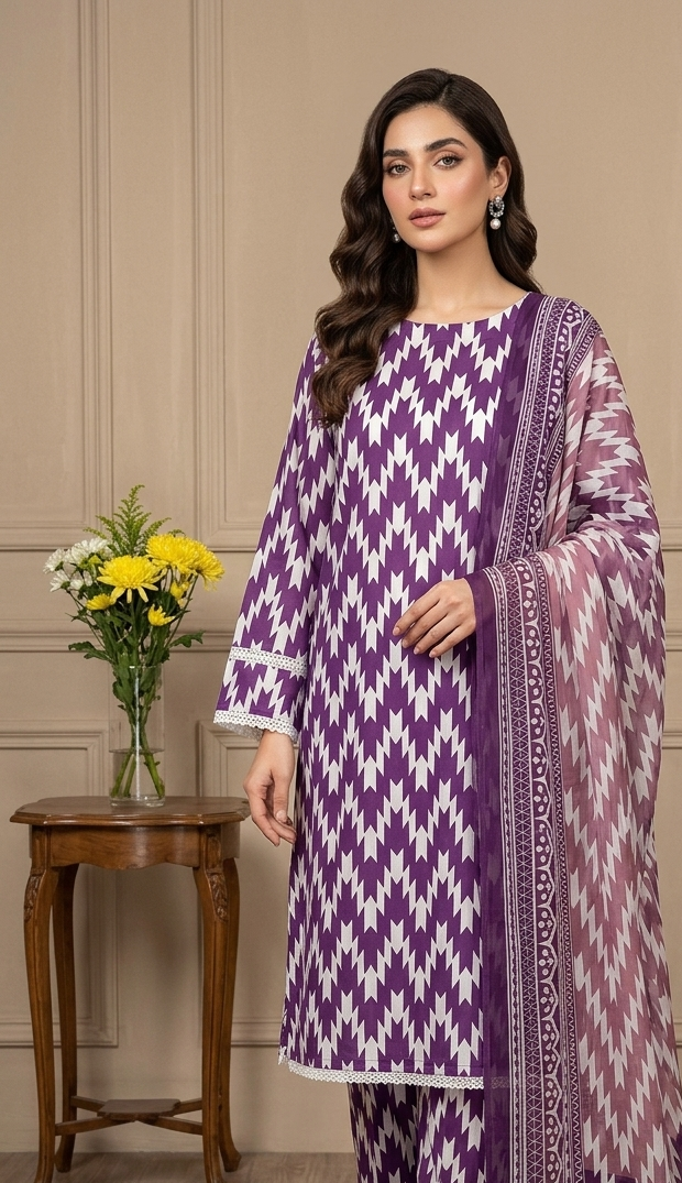 Woman wearing a purple and white patterned outfit in a room with a wooden table and flowers.