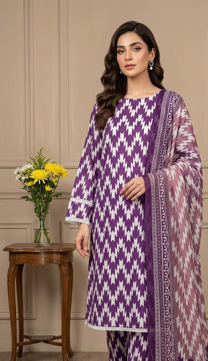Woman wearing a purple and white patterned outfit in a room with a wooden table and flowers.