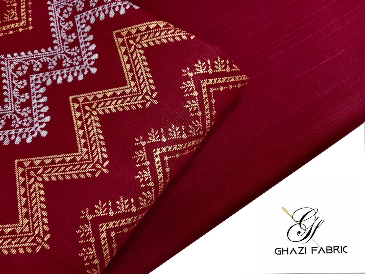 Close-up of red fabric with intricate gold and white patterns, featuring the Ghazi Fabrics logo.